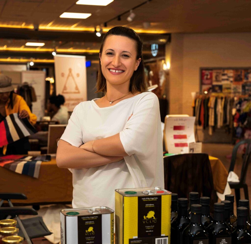 Femme souriante sur un stand présentant ses produits venant d'Italie