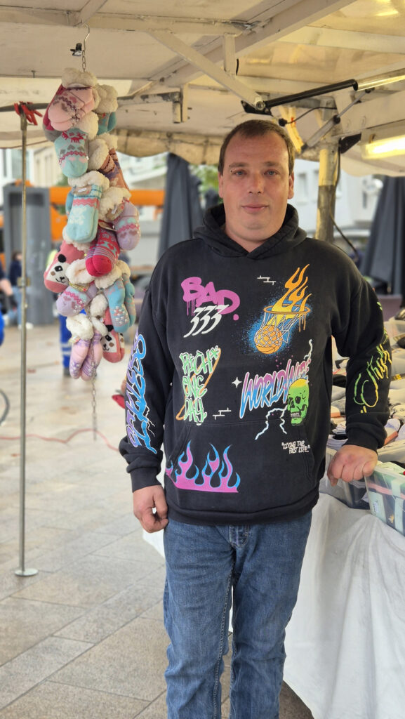 Un entrepreneur soutenu par microlux debout à côté de son stand